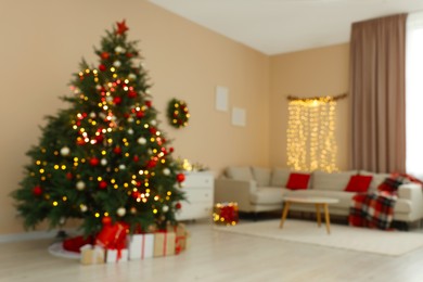 Blurred view of beautiful Christmas tree decorated with festive lights in stylish room. Interior design