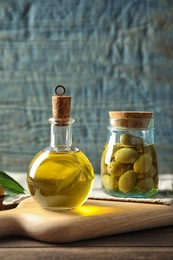 Composition with fresh olive oil on table