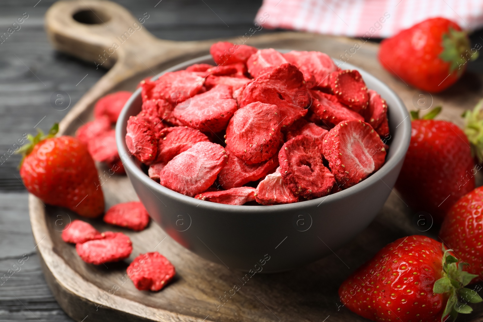 Photo of Freeze dried and fresh strawberries on wooden table, closeup