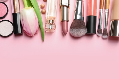 Makeup products and flower on color background, flat lay with space for text