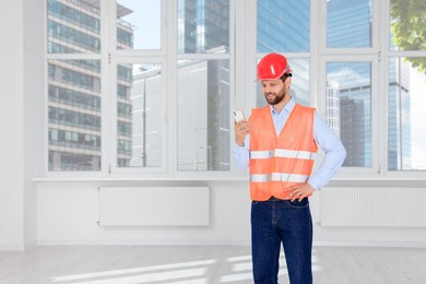 Man in reflective uniform with phone indoors, space for text