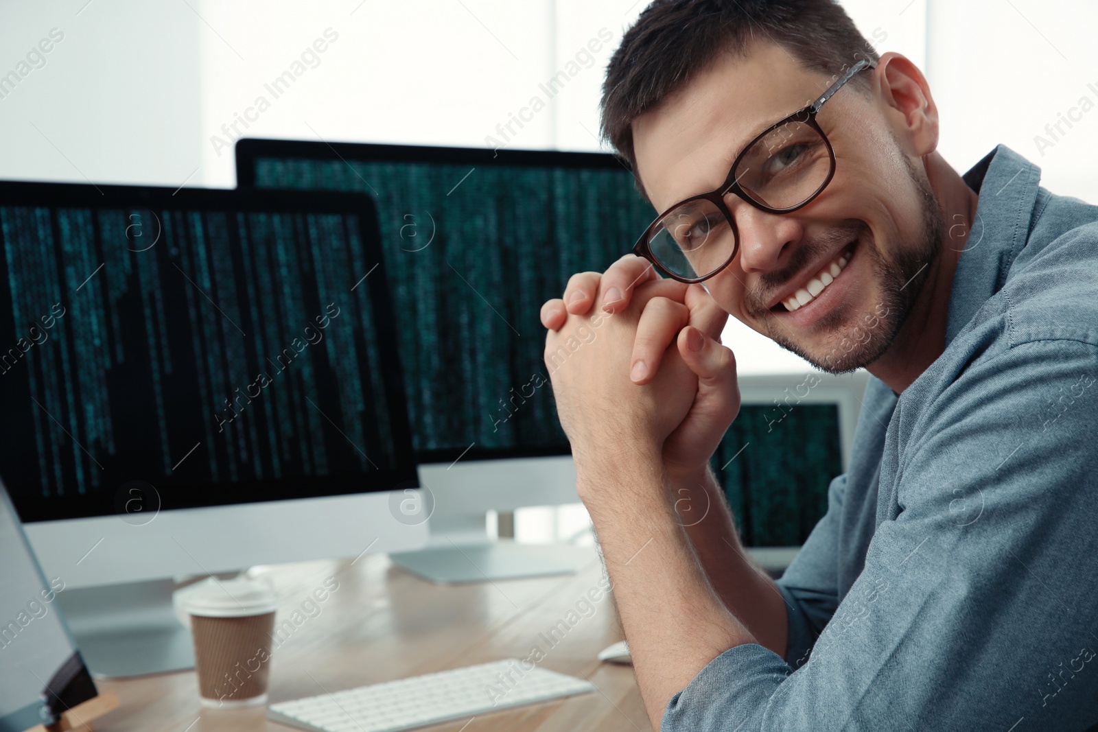 Photo of Happy programmer working at desk in office