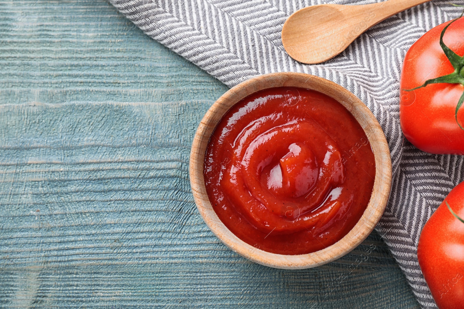 Photo of Tasty tomato sauce on blue wooden table, flat lay. Space for text