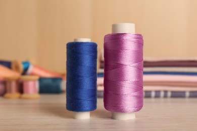 Photo of Different color sewing threads on wooden table