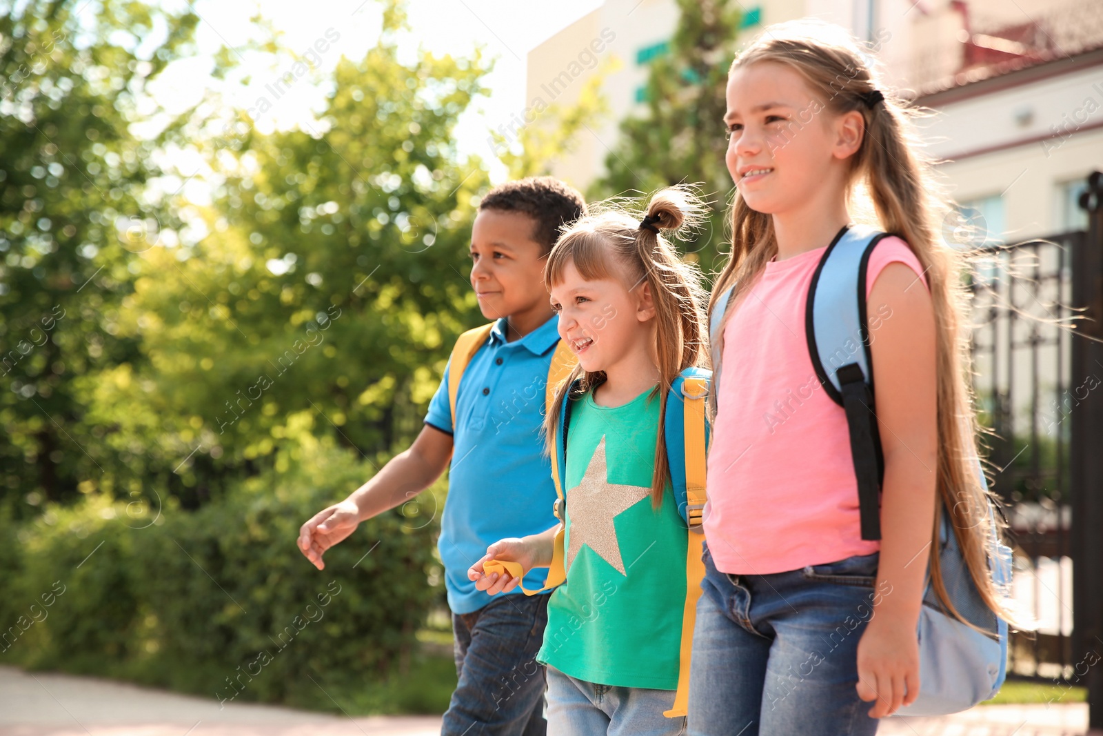 Photo of Cute little children with backpacks going to school