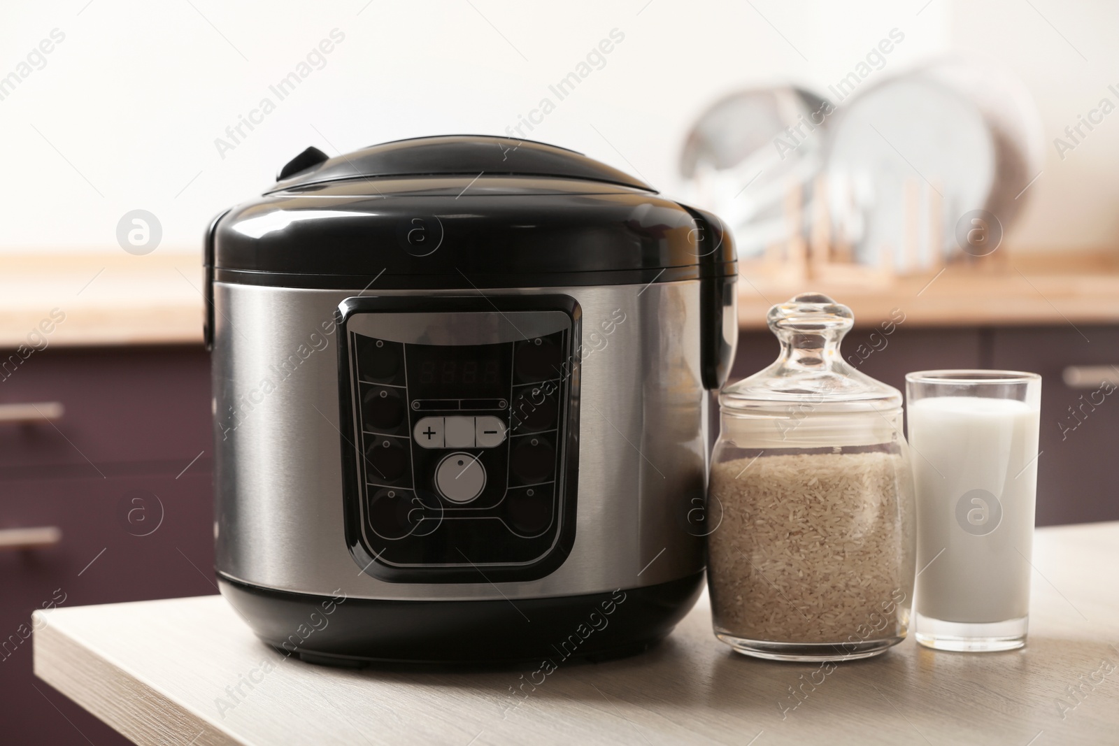 Photo of Modern multi cooker and products on table in kitchen