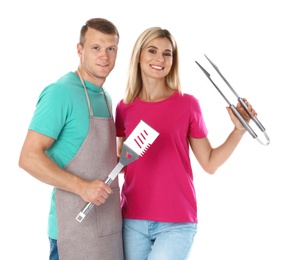 Happy couple with barbecue utensils on white background