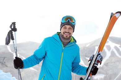 Man with ski equipment spending winter vacation in mountains