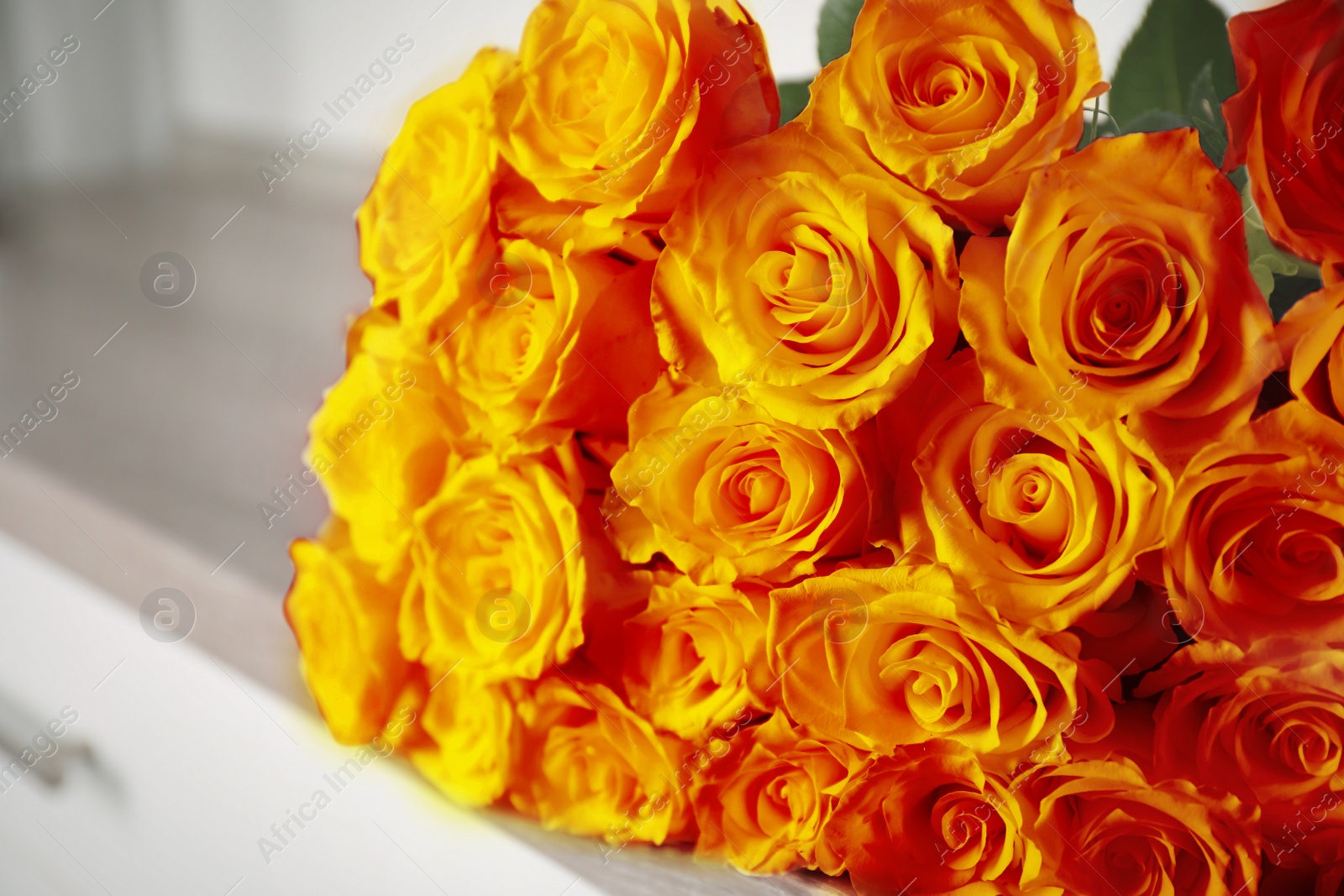 Image of Beautiful bouquet of orange roses on commode, closeup