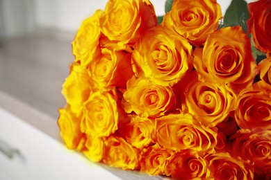 Beautiful bouquet of orange roses on commode, closeup