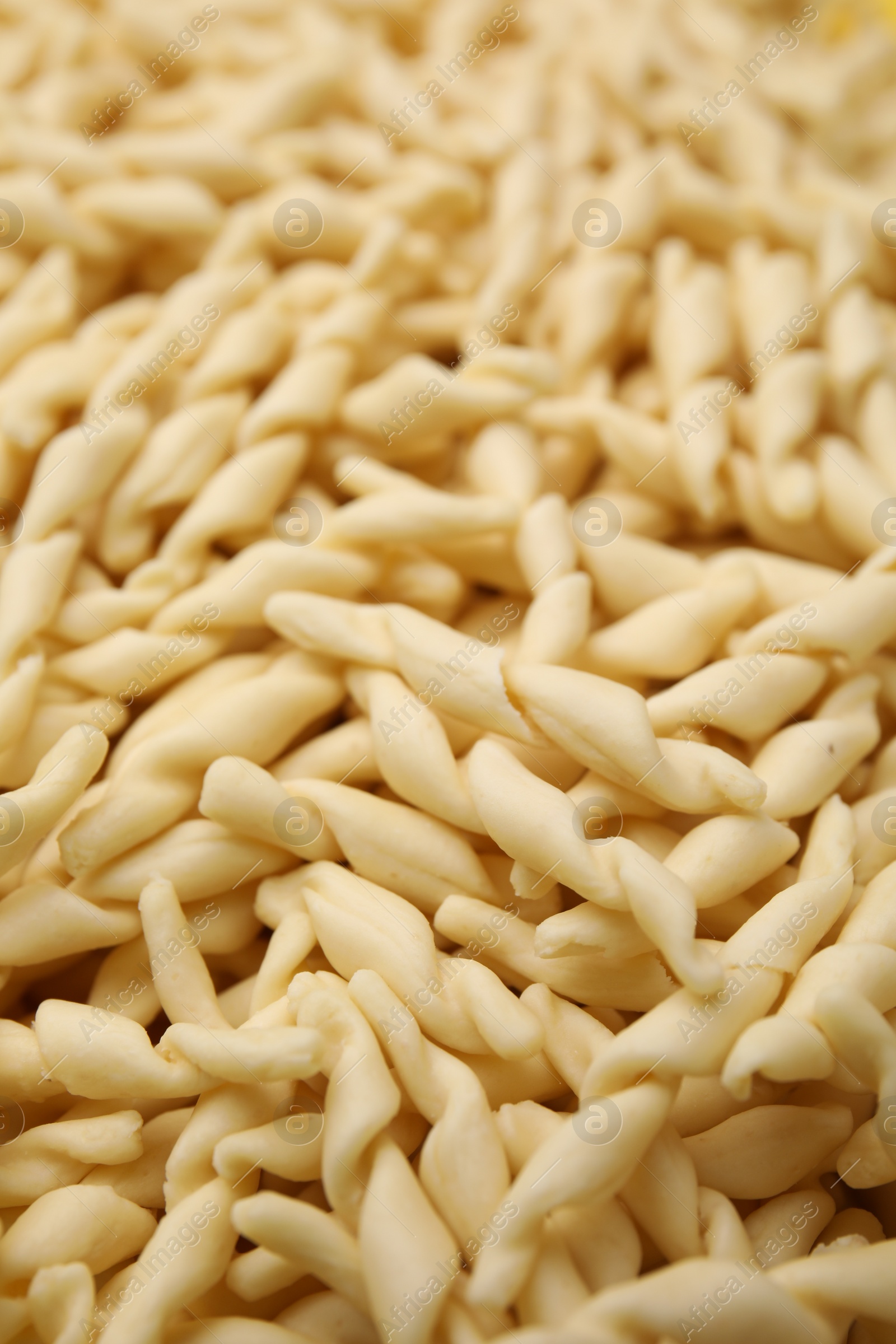 Photo of Uncooked trofie pasta as background, closeup view