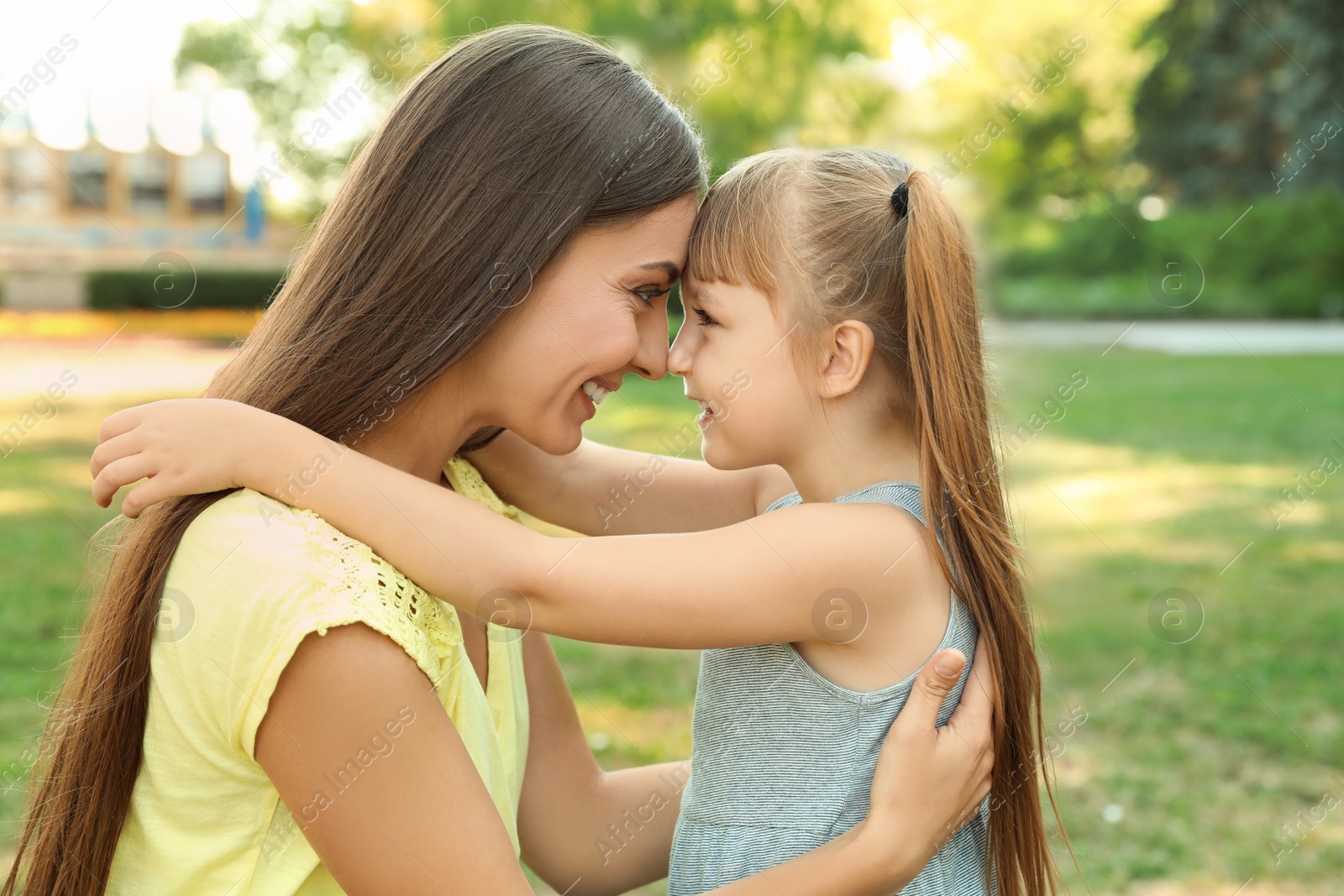 Photo of Mother with her cute child in green park on sunny day. Happy family