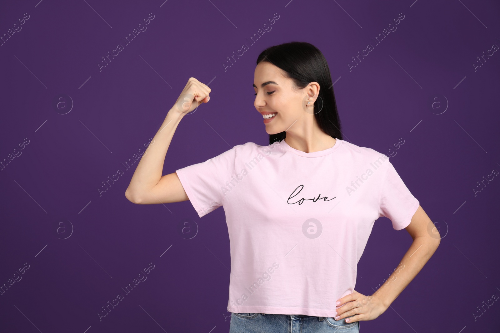 Photo of Strong woman as symbol of girl power on purple background. 8 March concept