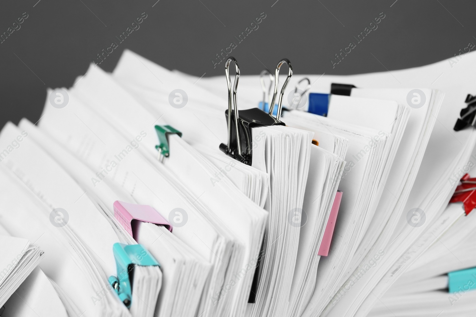 Photo of Pile of documents with colorful binder clips, closeup