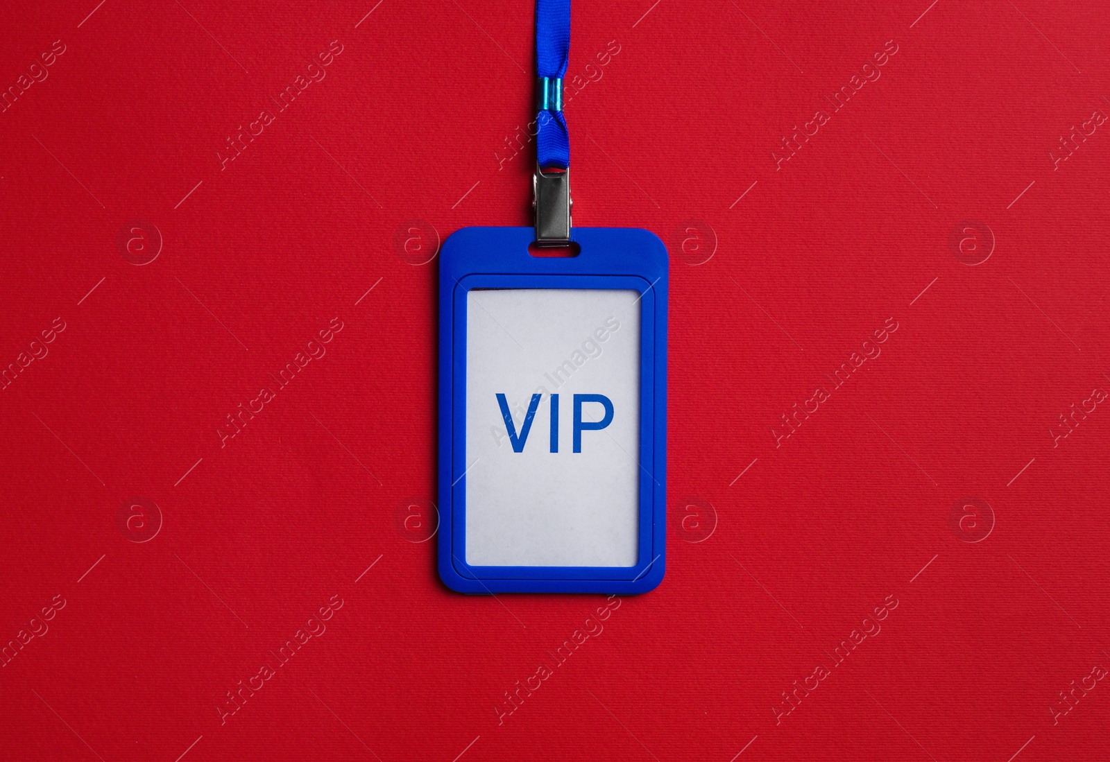 Photo of Plastic vip badge on red background, top view