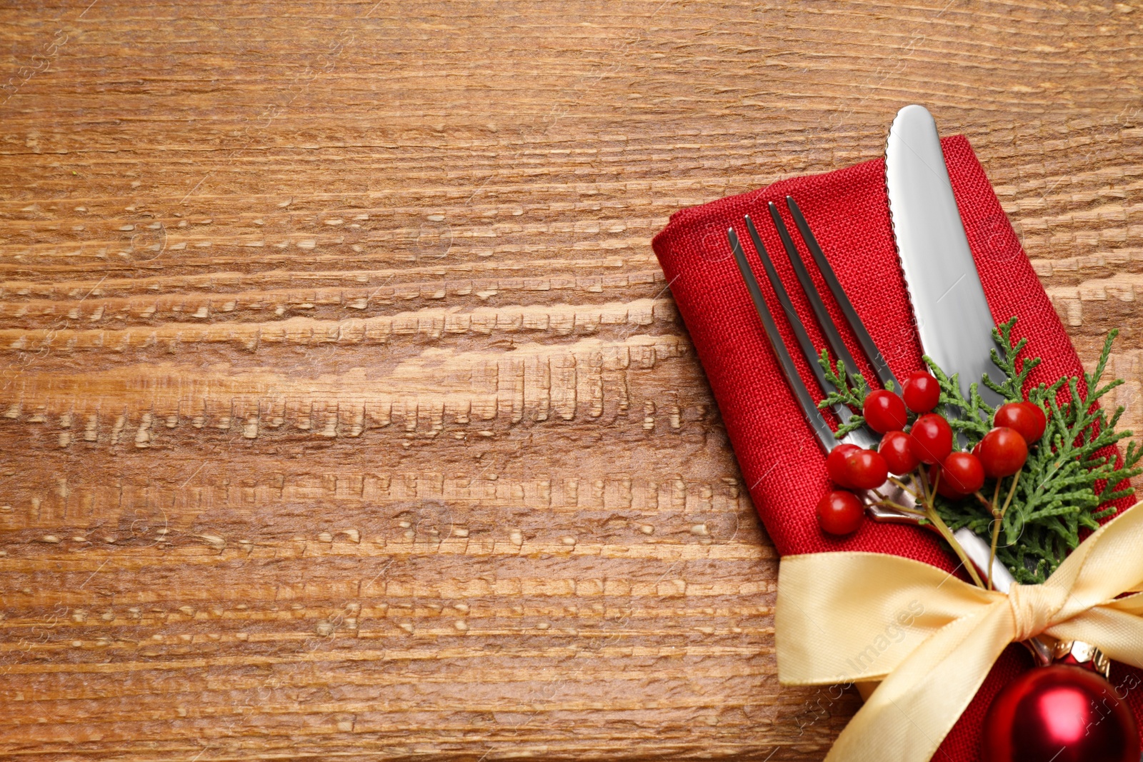 Photo of Cutlery set on wooden table, space for text. Christmas celebration