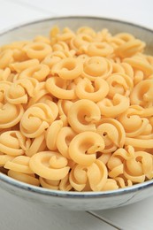 Raw dischi volanti pasta in bowl on table, closeup