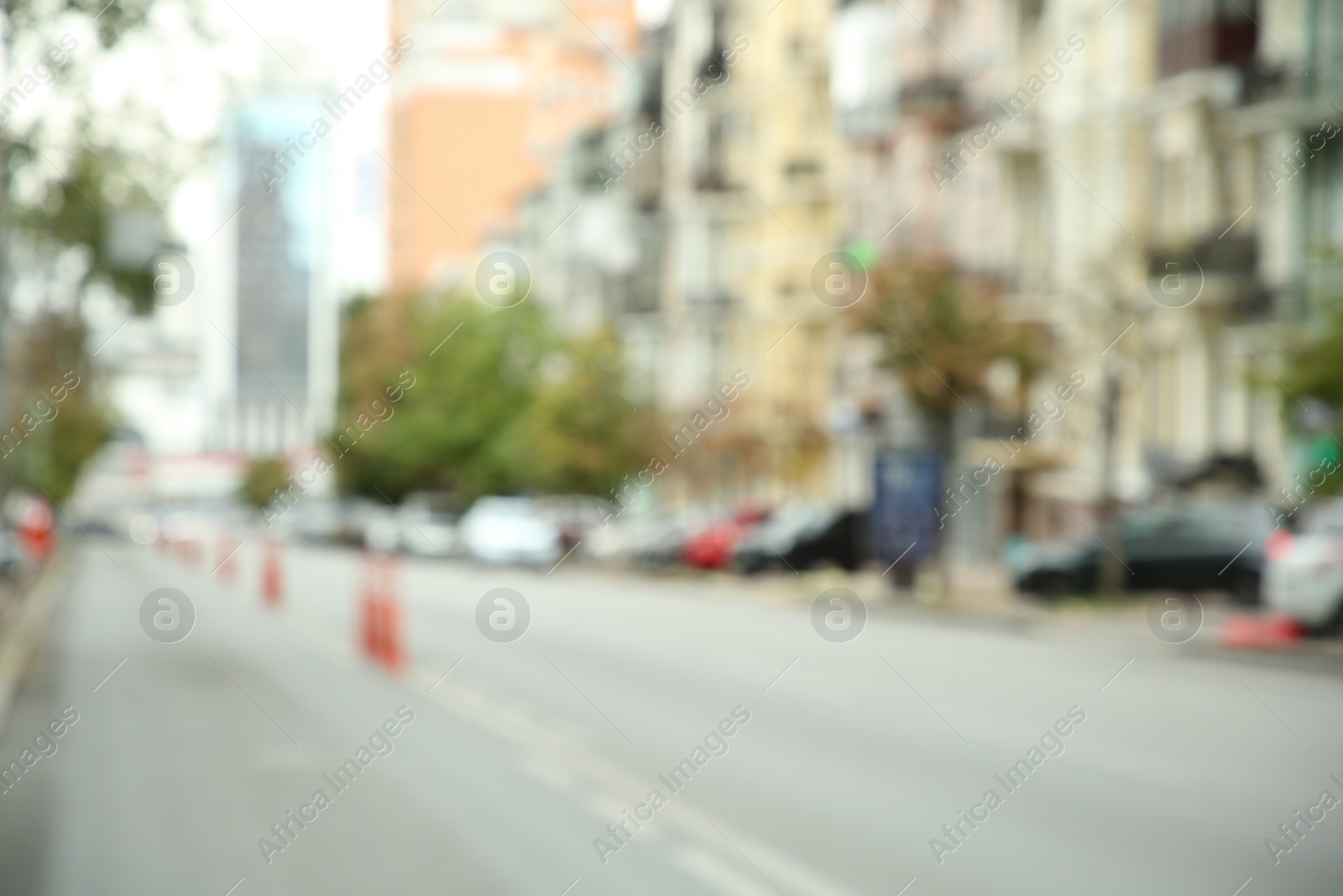 Photo of Blurred view of quiet city with buildings and cars on road