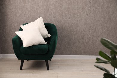 Photo of Soft pillows on armchair in living room. Space for text