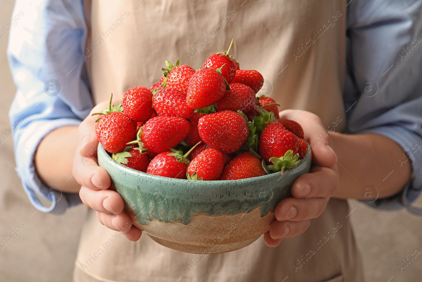 Photo of Young woman holding bowl with fresh ripe strawberries, closeup