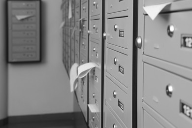 Photo of Closed grey metal mailboxes with receipts indoors, closeup. Space for text