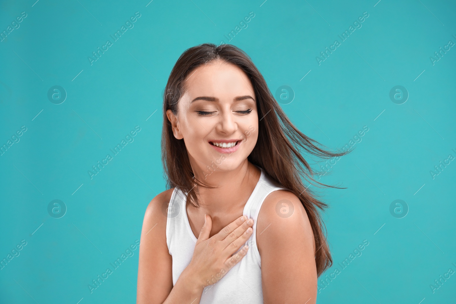 Photo of Emotional young woman in casual outfit on turquoise background