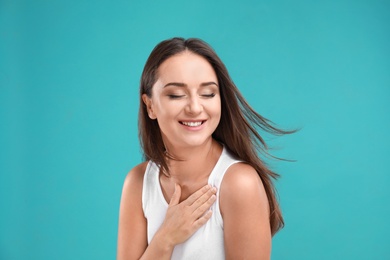 Emotional young woman in casual outfit on turquoise background