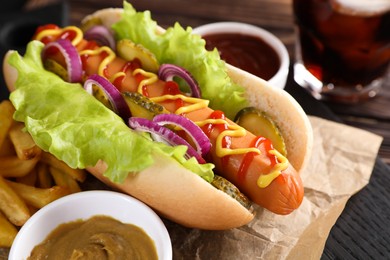 Photo of Delicious hot dog with lettuce, onion and pickle served on table, closeup