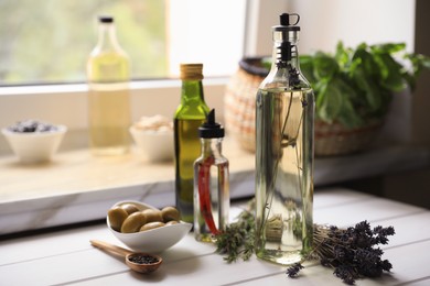 Photo of Different cooking oils and ingredients on white wooden table indoors