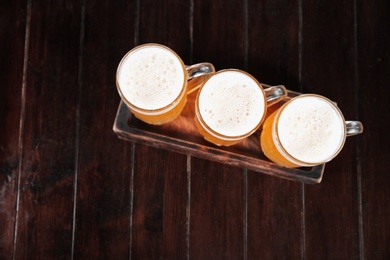 Photo of Glasses of tasty beer on wooden table