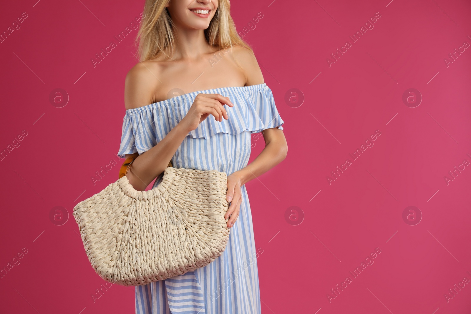 Photo of Young woman with stylish straw bag on pink background, closeup. Space for text