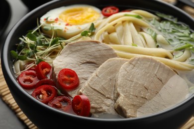 Photo of Delicious ramen with meat in bowl on table, closeup. Noodle soup