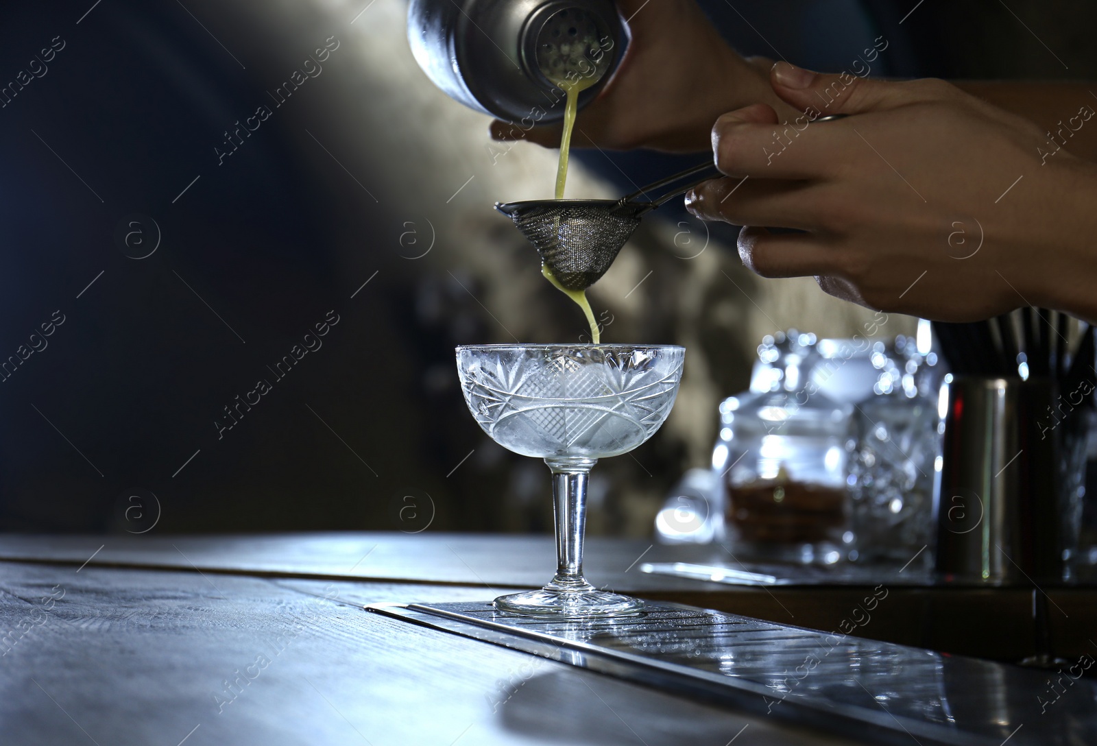 Photo of Bartender preparing fresh alcoholic cocktail at bar counter, closeup