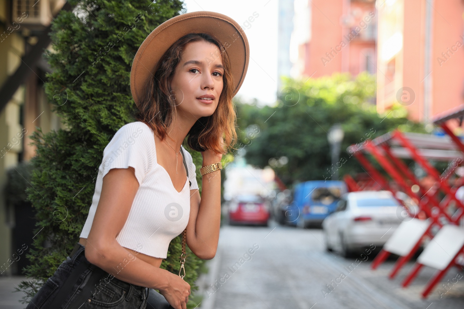 Photo of Portrait of beautiful young woman on city street. Space for text