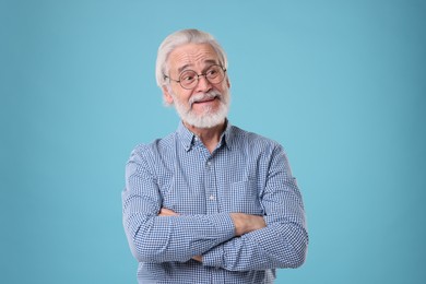 Photo of Portrait of stylish grandpa with glasses on light blue background