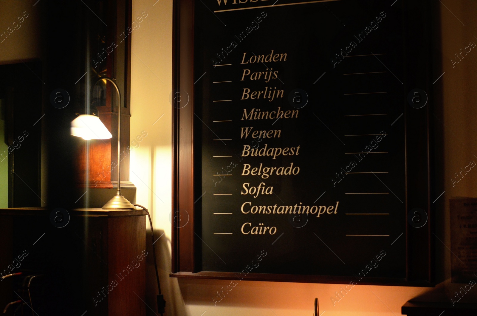 Photo of Black board with different city names indoors