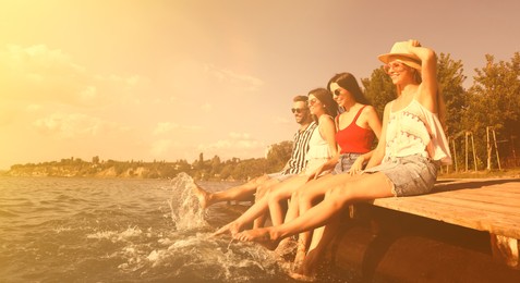 Image of Group of friends having fun near river at summer party. Banner design