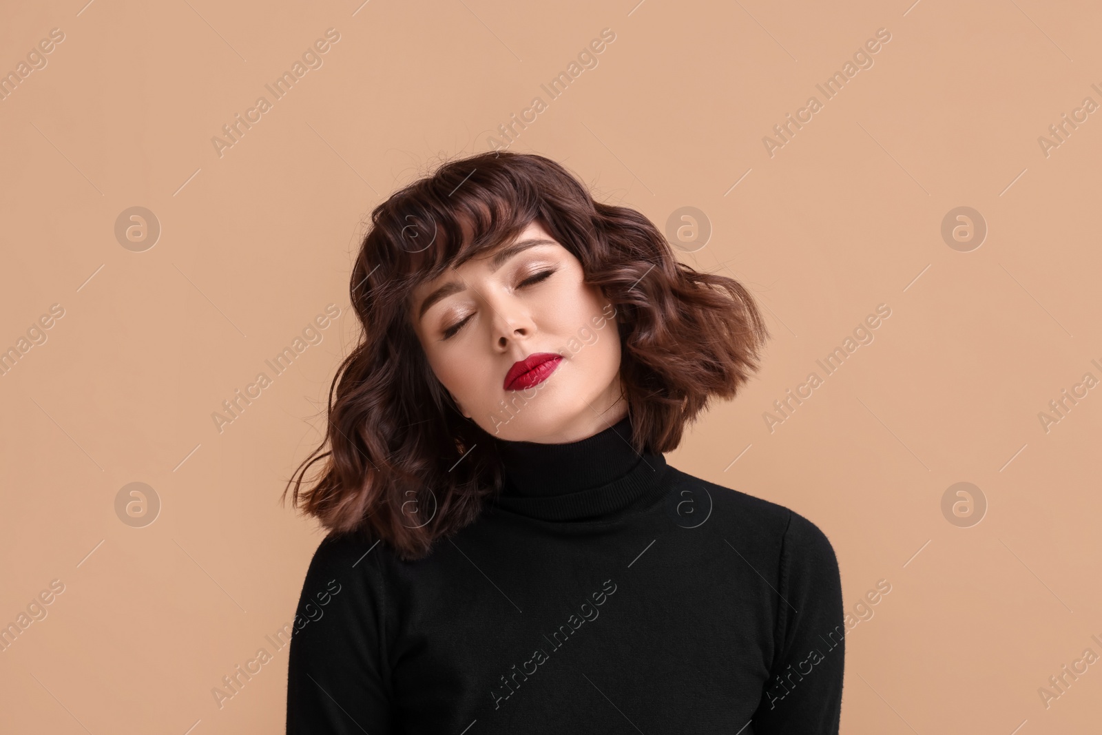 Photo of Portrait of beautiful young woman with wavy hairstyle on beige background