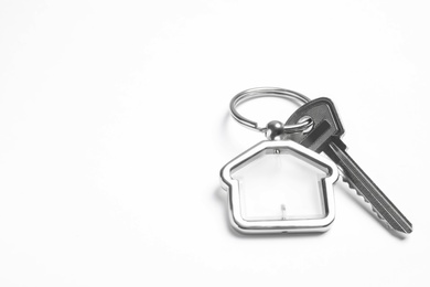 Photo of House key with trinket on white background. Space for text