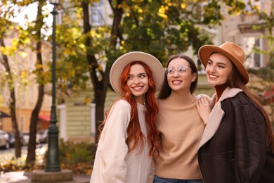 Photo of Portrait of happy friends spending time together outdoors. Space for text