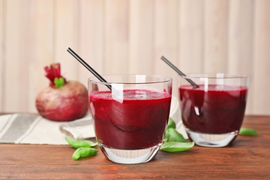 Photo of Glasses of fresh beet juice on wooden table