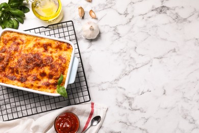 Photo of Tasty cooked lasagna in baking dish on white marble table, flat lay. Space for text