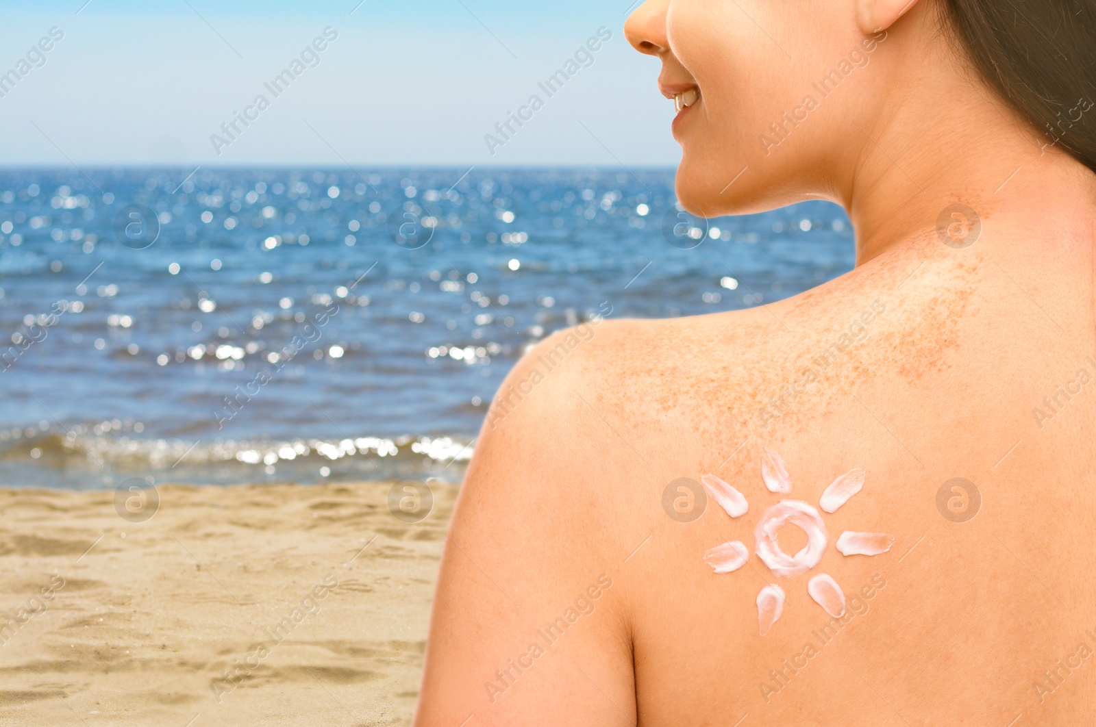 Image of Sun protection. Woman with sunblock on her back near sea, closeup