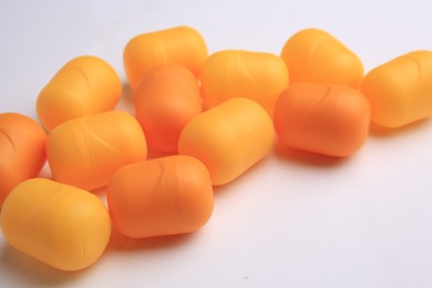 Sveti Vlas, Bulgaria - June 30, 2023: Orange plastic capsules from Kinder Surprise Eggs on white background, closeup