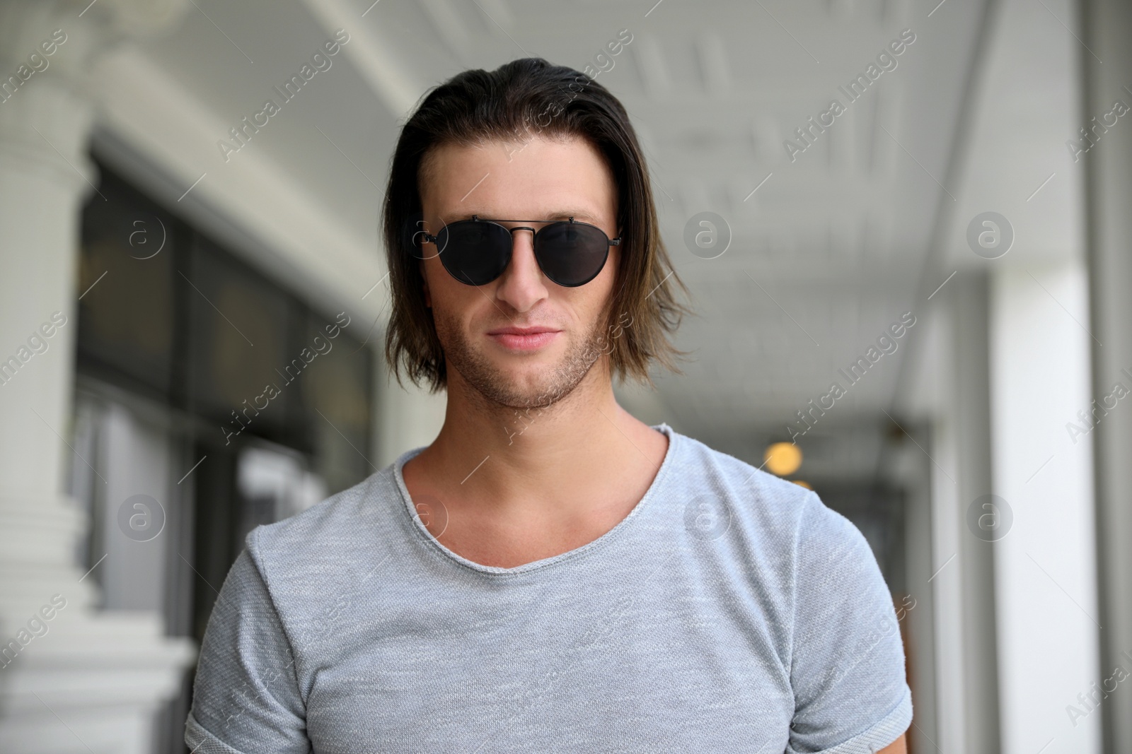 Photo of Portrait of handsome young man in stylish sunglasses outdoors