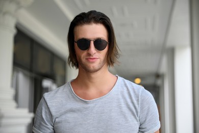 Photo of Portraithandsome young man in stylish sunglasses outdoors