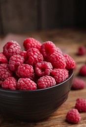 Photo of Bowl with fresh ripe raspberries on wooden table, closeup