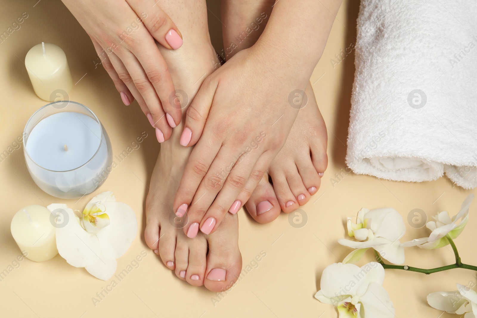 Photo of Closeup of woman with neat toenails after pedicure procedure on beige background, top view