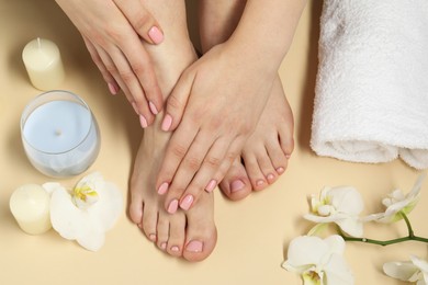 Photo of Closeup of woman with neat toenails after pedicure procedure on beige background, top view
