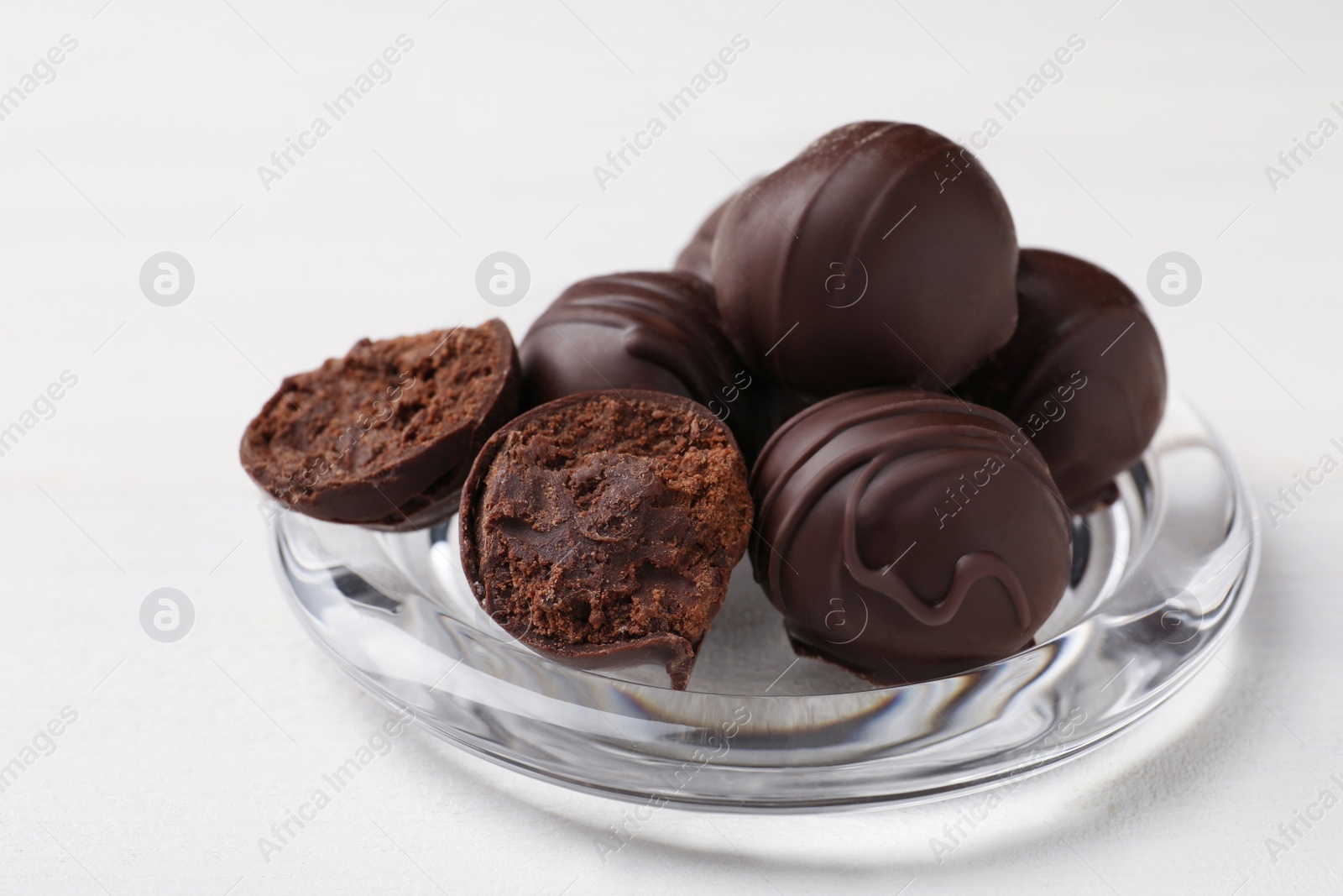 Photo of Many delicious chocolate truffles on white wooden table, closeup